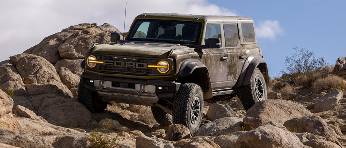 Brown Ford Bronco driving over rocks