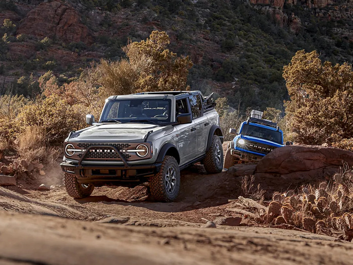 2 Ford Broncos driving over rocks
