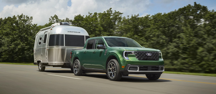 Green Ford Maverick Towing a trailer