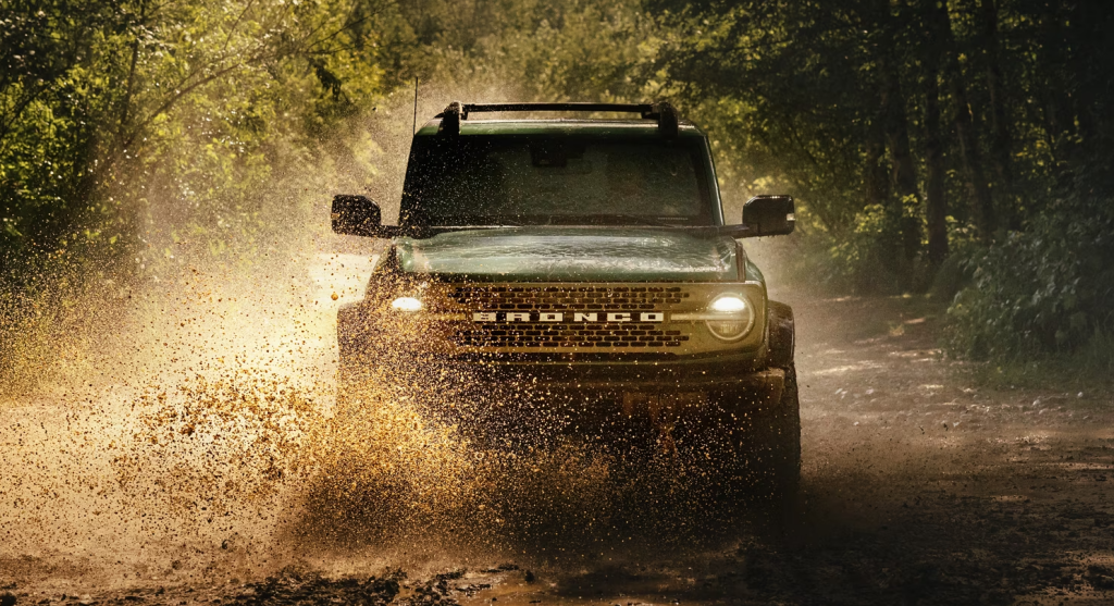 Green 2025 Ford Bronco® SUV fording a stream in the woods