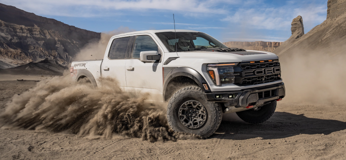 White 2025 Ford F-150® Raptor R® racing across the desert leaving a trail of dust behind