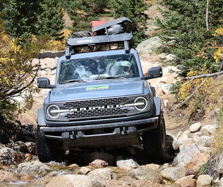 Custom Ford Bronco driving over rocks